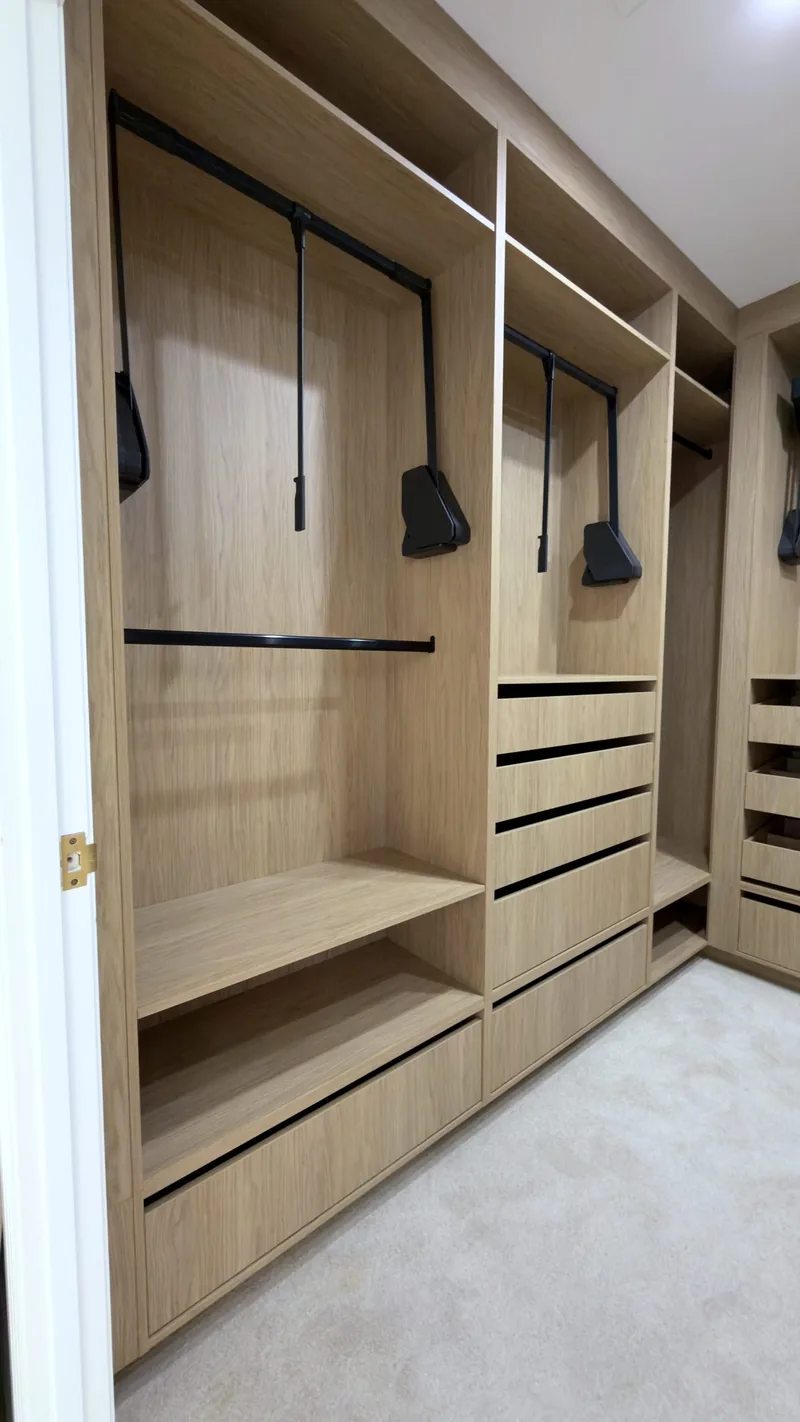Oak wardrobe bays with pull-down hanging rails, open shelves and drawers