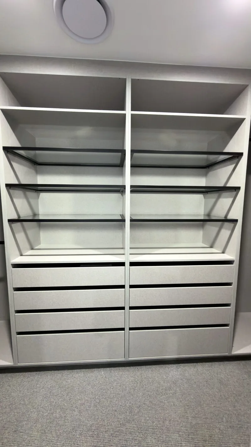 Grey wardrobe with two bays of glass shelves above a double drawer bank