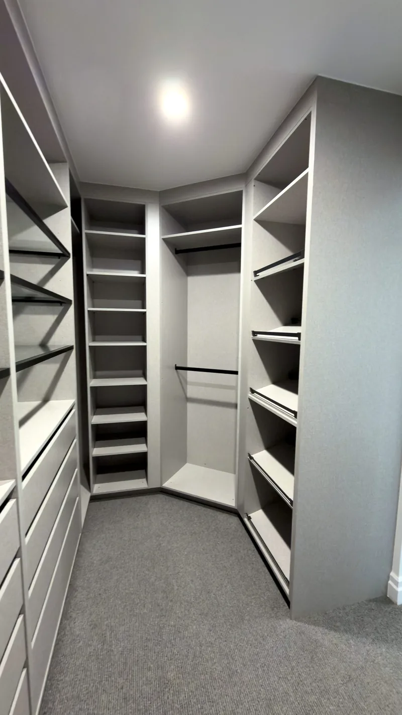 Grey U-shaped walk-in wardrobe with shoe shelves, hanging space and drawers