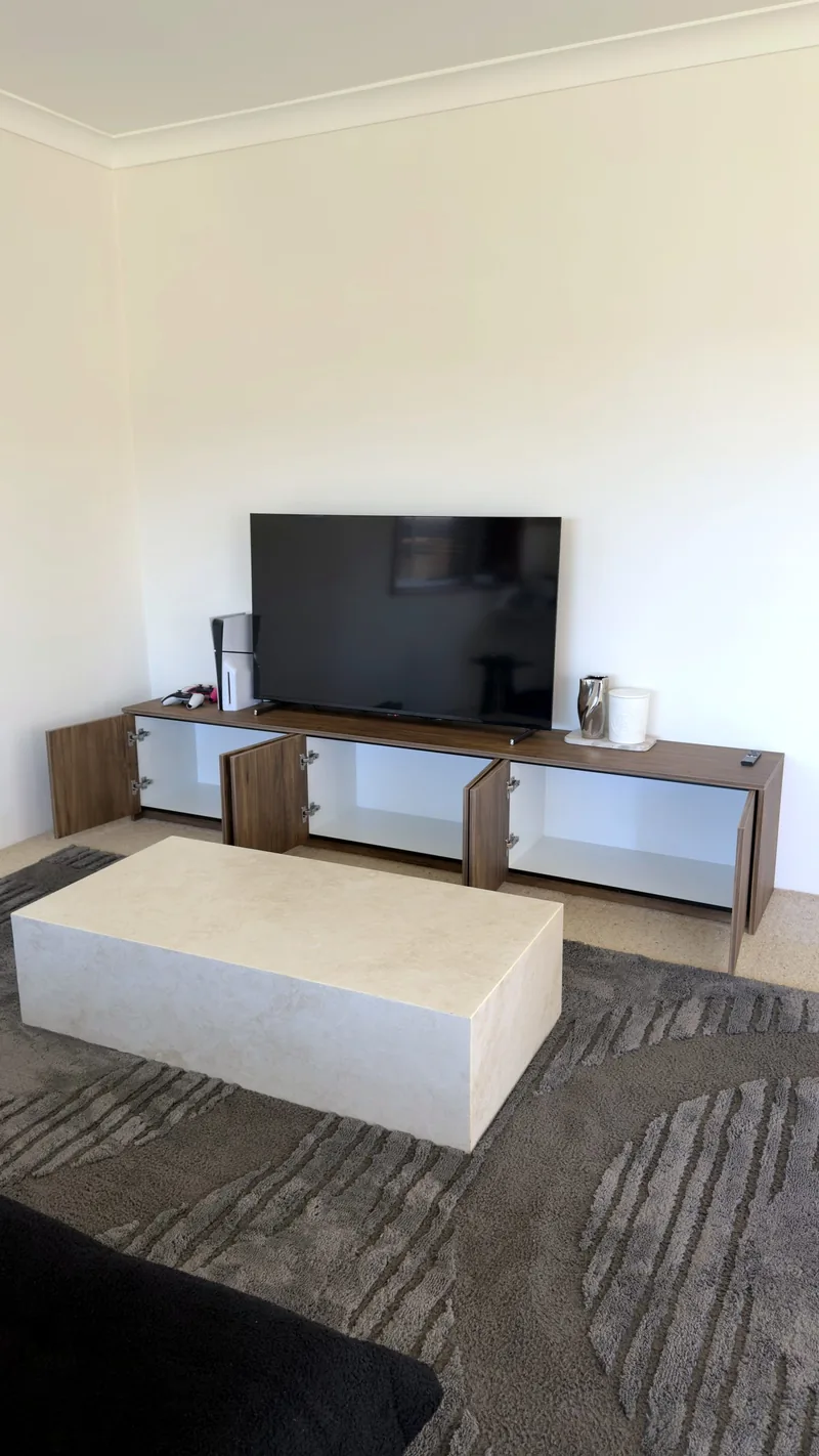 Walnut TV unit with its cabinet doors open, showing the white interior shelves
